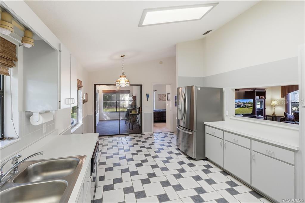 THE HEART OF THE HOME! Functional kitchen layout offers GRAY CABINETRY, STAINLESS STEEL REFRIGERATOR, PASS-THROUGH TO LIVING ROOM & convenient access to adjoining spaces!