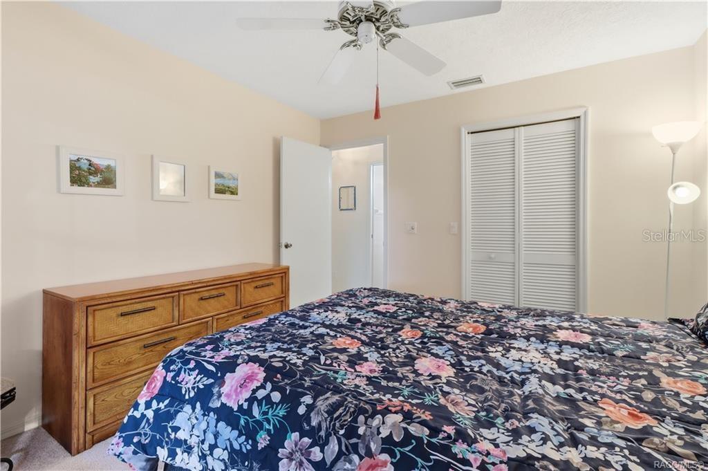Guest bedroom featuring neutral walls, carpeting, ceiling fan and double-door closet.