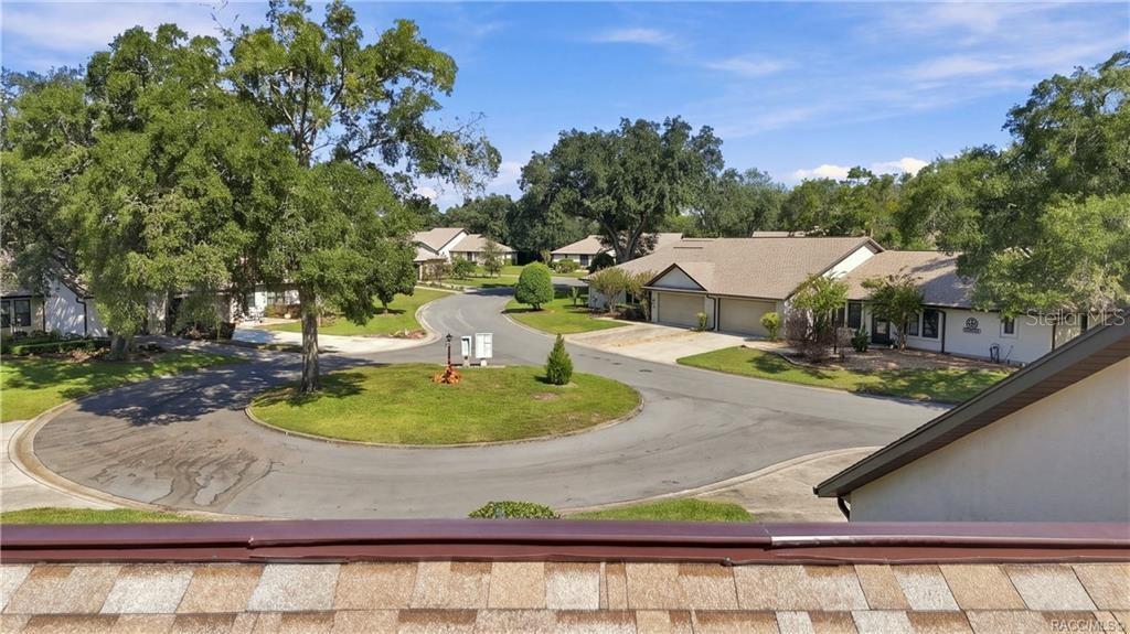 COMMUNITY CUL-DE-SAC VIEWA bird's-eye view of the neighborhood's peaceful cul-de-sac setting, surrounded by mature shade trees, landscaped lawns, and neighboring residences.