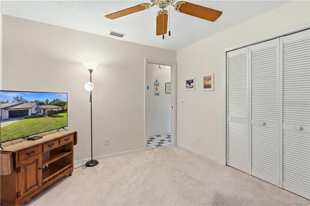 Guest bedroom with double-door closet, neutral finishes, and convenient access to the adjoining hallway.