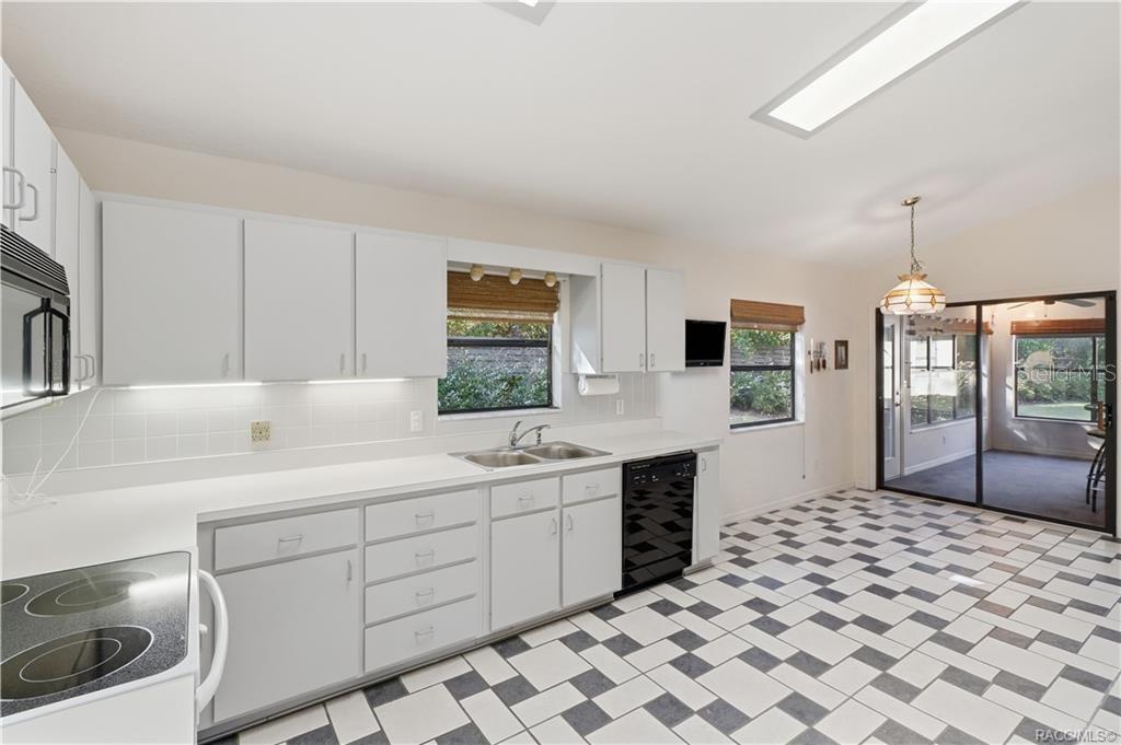 A KITCHEN WITH ROOM TO MOVE! Generous countertop space, abundant cabinetry, DOUBLE-BASIN SINK & convenient access to the ENCLOSED FLORIDA ROOM!