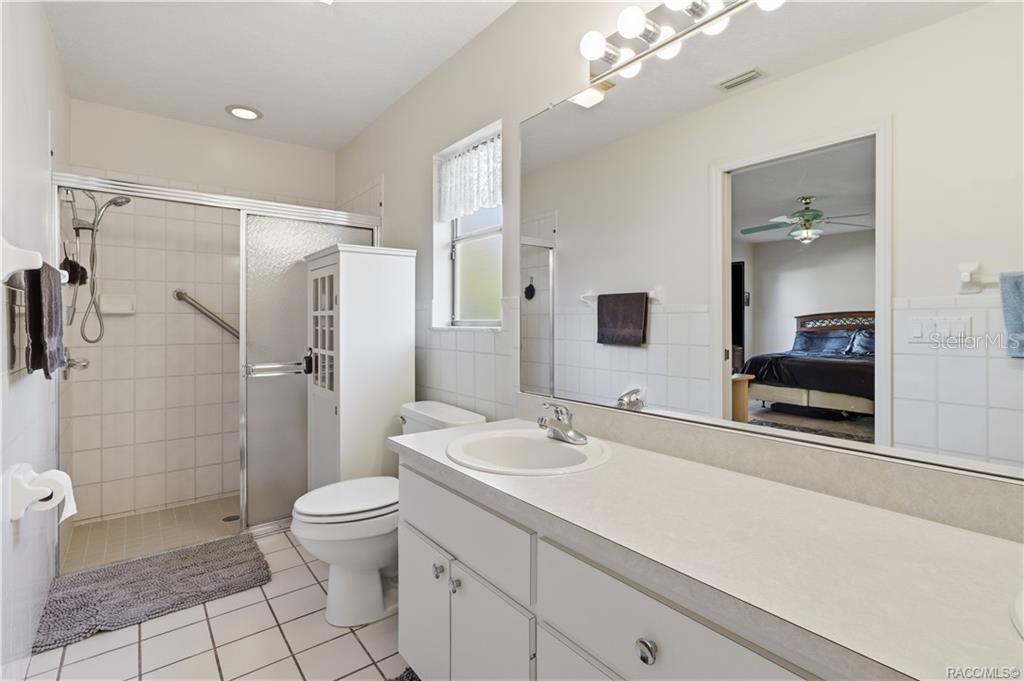 EVERYDAY COMFORT! PRIMARY BATH features a spacious VANITY, LARGE MIRROR, WALK-IN SHOWER & convenient storage!