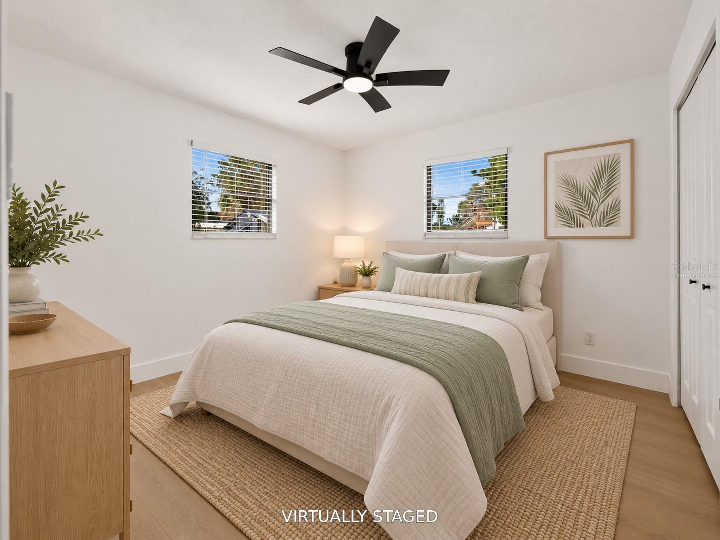 VIRTUALLY STAGED. Additional bedroom featuring a sleek black ceiling fan and updated flooring.