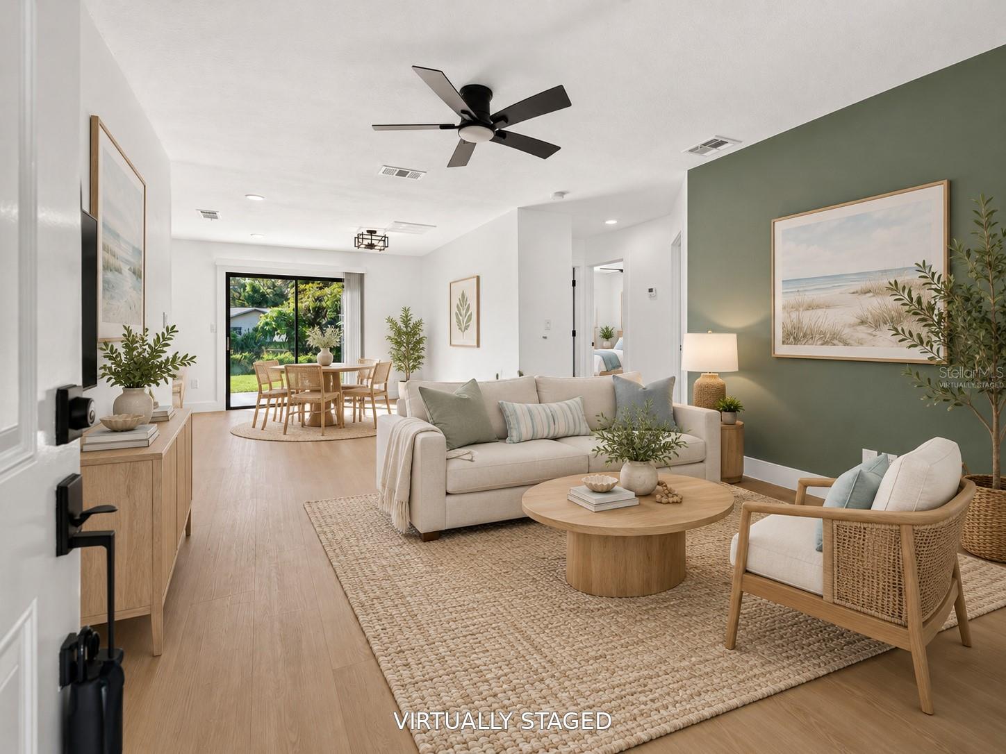 VIRTUALLY STAGED. Spacious living area featuring a modern sage green accent wall. VIRTUALLY STAGED. Spacious living area featuring a modern sage green accent wall.