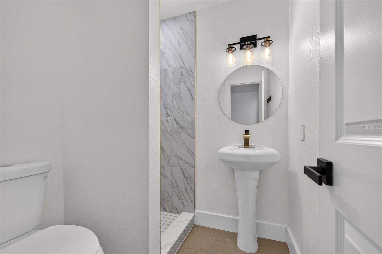 Beautifully updated ensuite bathroom featuring modern finishes and elegant gold accents.