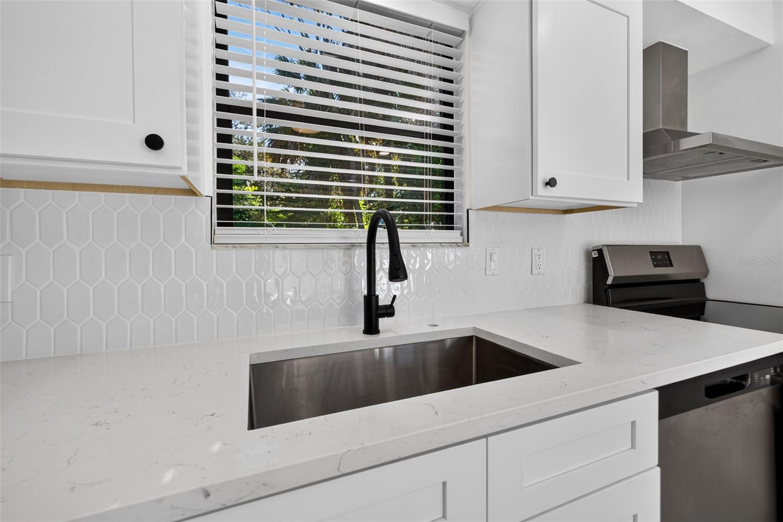 Bright white cabinetry, quartz countertops, and stylish finishes.