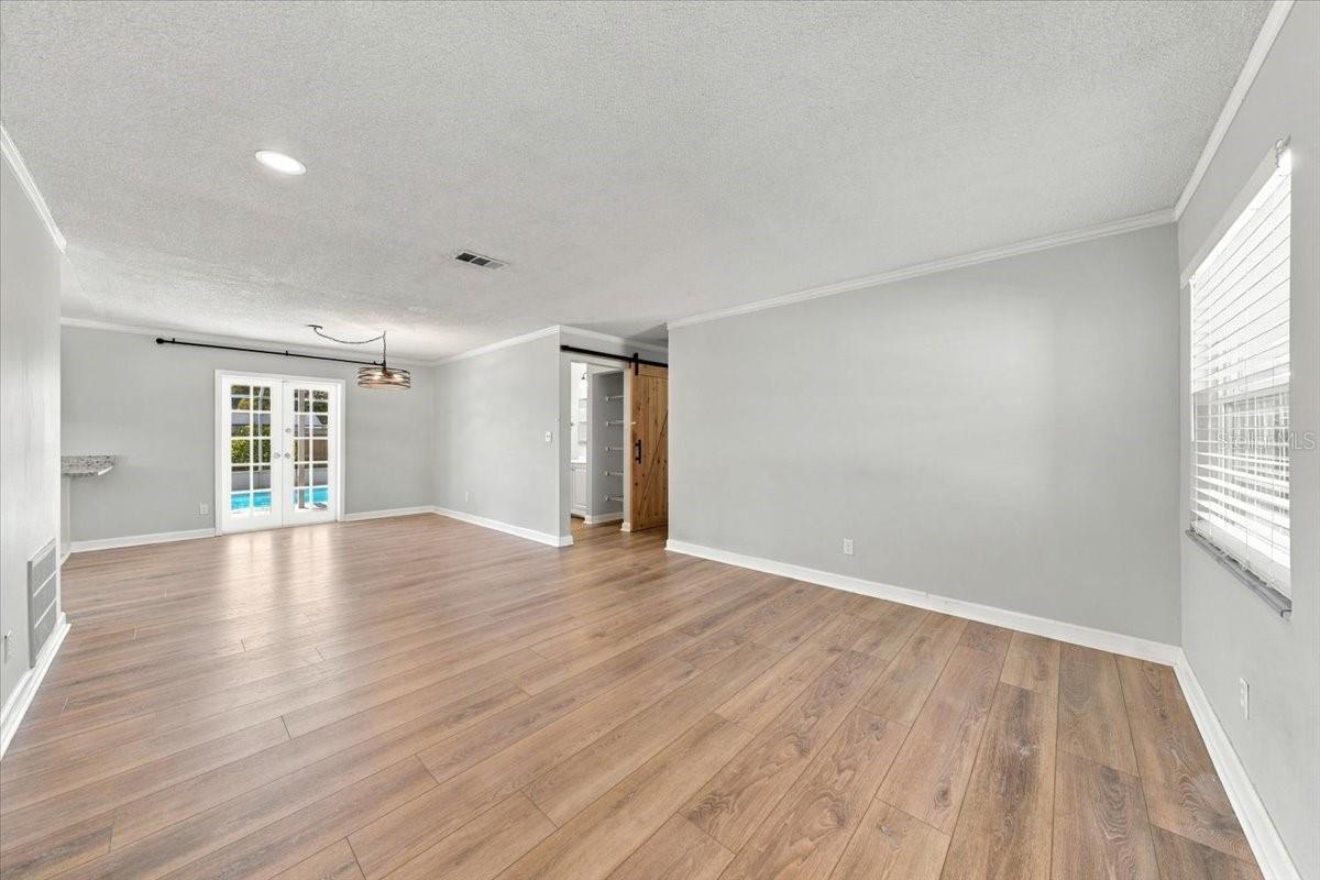 Living room and dining area with french doors to the pool
