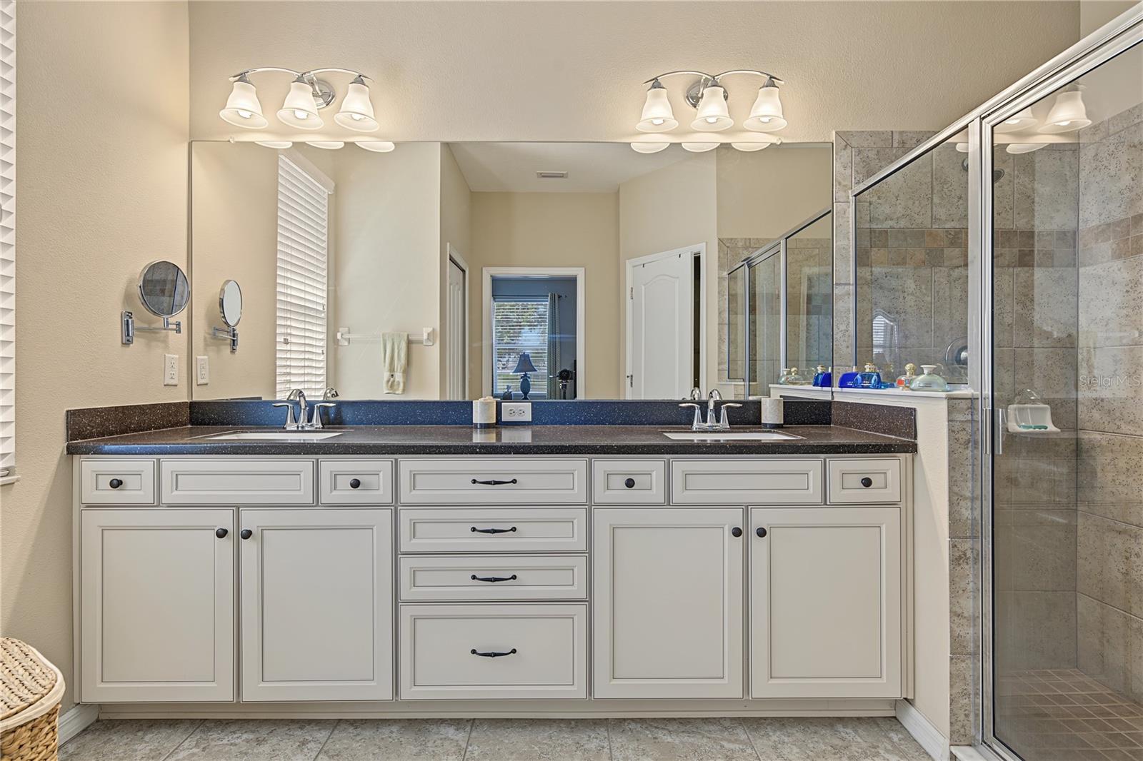 Bath ensuite boast raised cabinets and quartz counter with dual sinks
