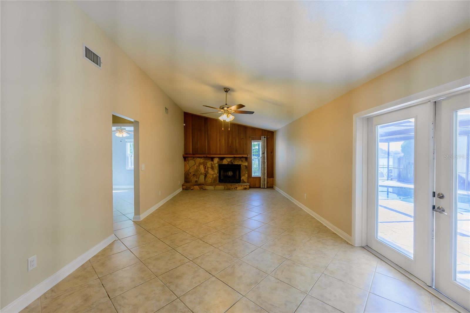 Family room with French doors leading to screen enclosed pool