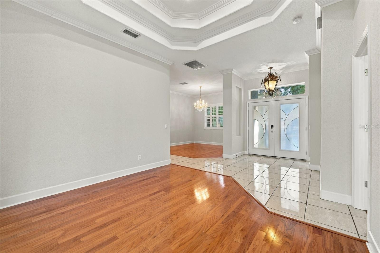 Formal Living Room with Double Step Tray Ceiling adorned in Crown Molding! Real Wood Flooring & 5 1/4 Baseboards