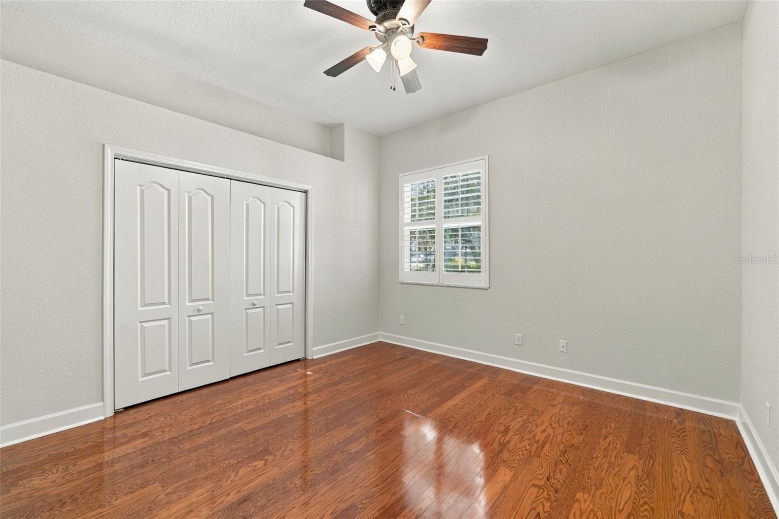 Bedroom 2 with Real Wood Floors, 5 1/4 Baseboards, Plantation Shutters and the Interior was just painted!