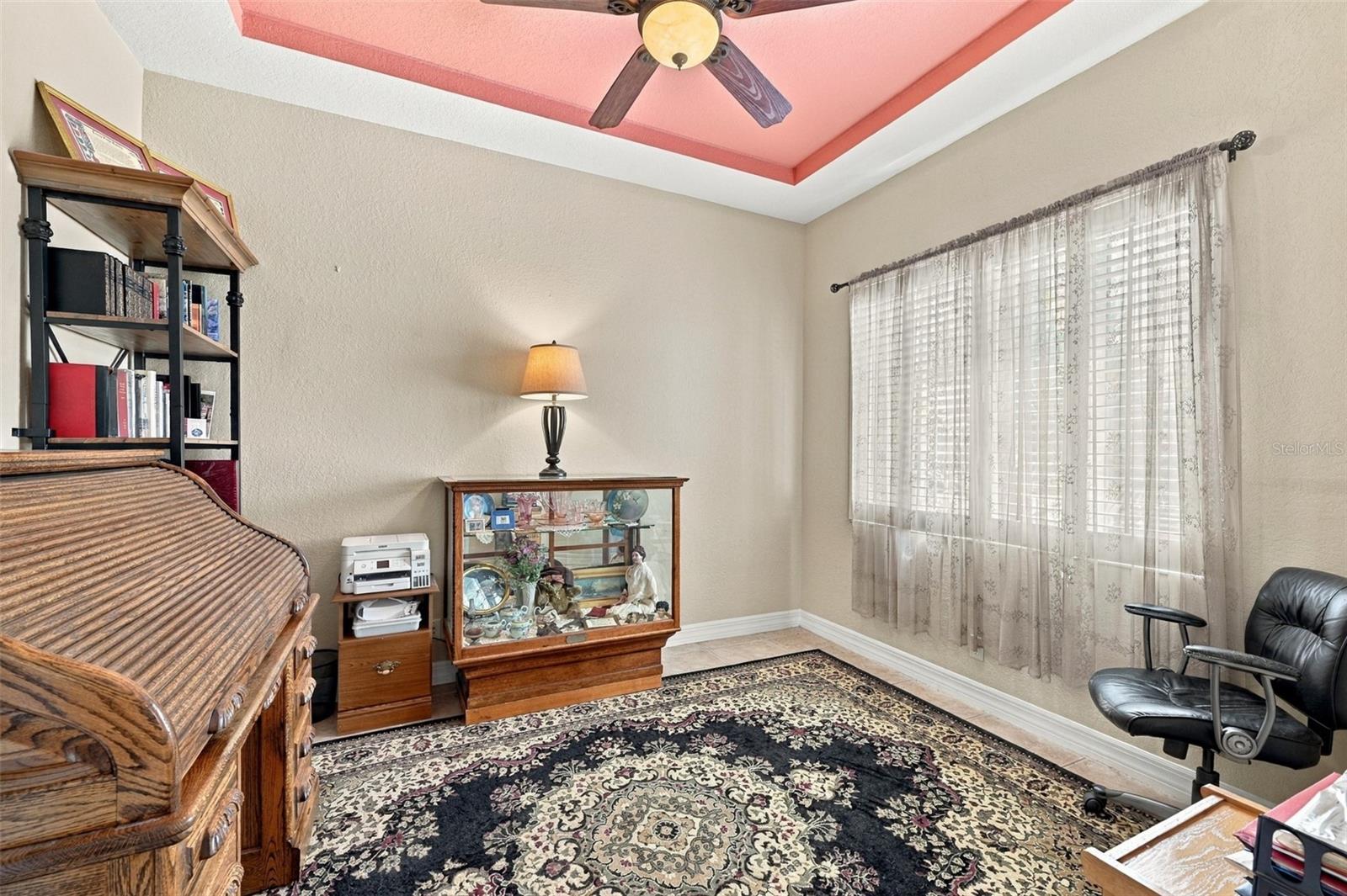 The room is bright and open with plantation shutters and a tray ceiling for elegance.