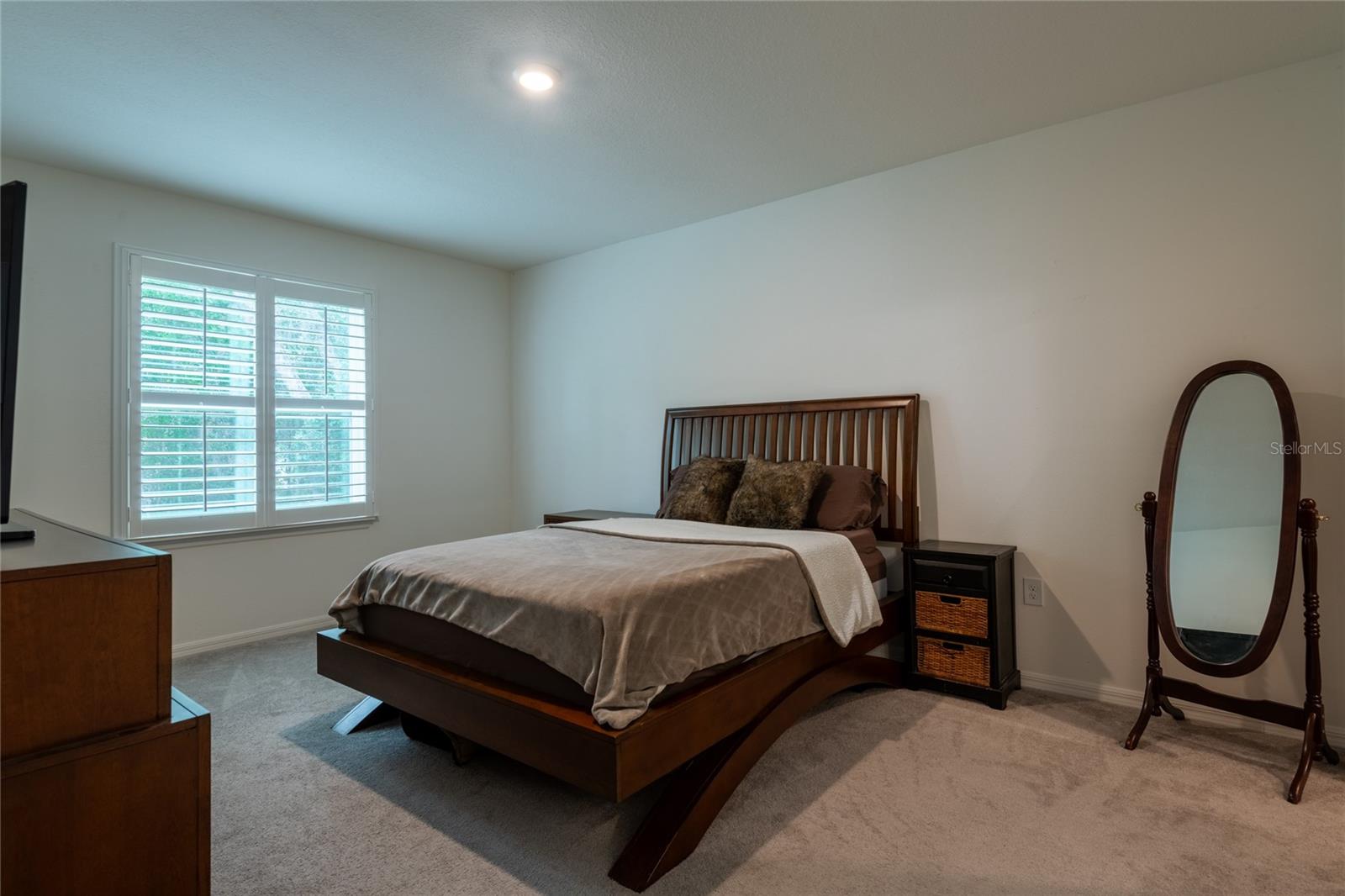 Primary bedroom with plantation shutters.