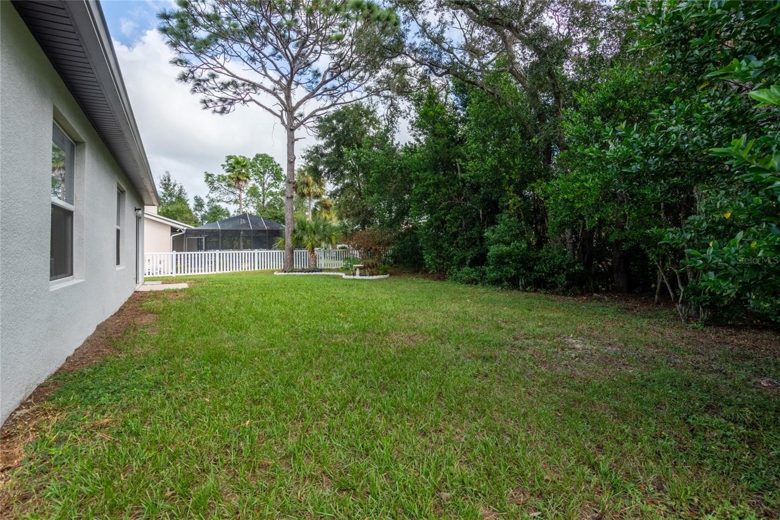 Large backyard bordered with trees for privacy.
