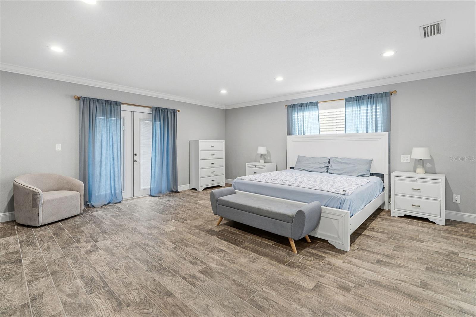 Primary bedroom with French doors to patio and pool.