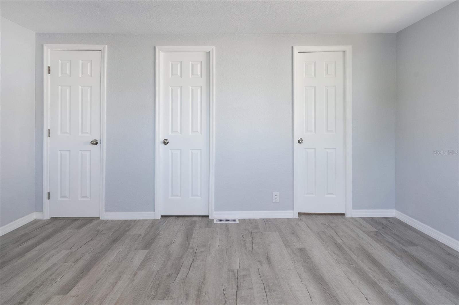 Bedroom 1 Left door to hallway, center door to walk in closet, right door to bathroom