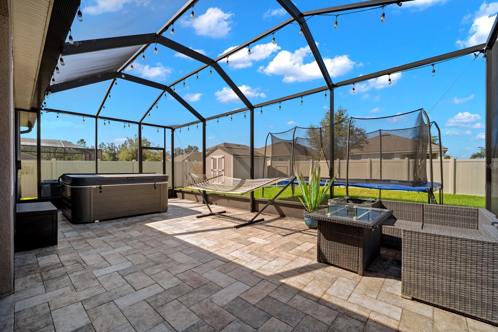 Large screened lanai with pavers, hot tub and room for lounging