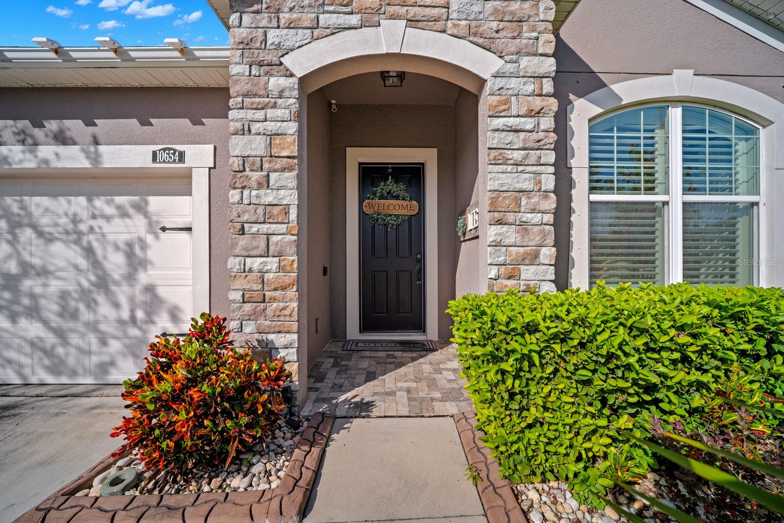 Covered front entry with stone columns and arched doorway