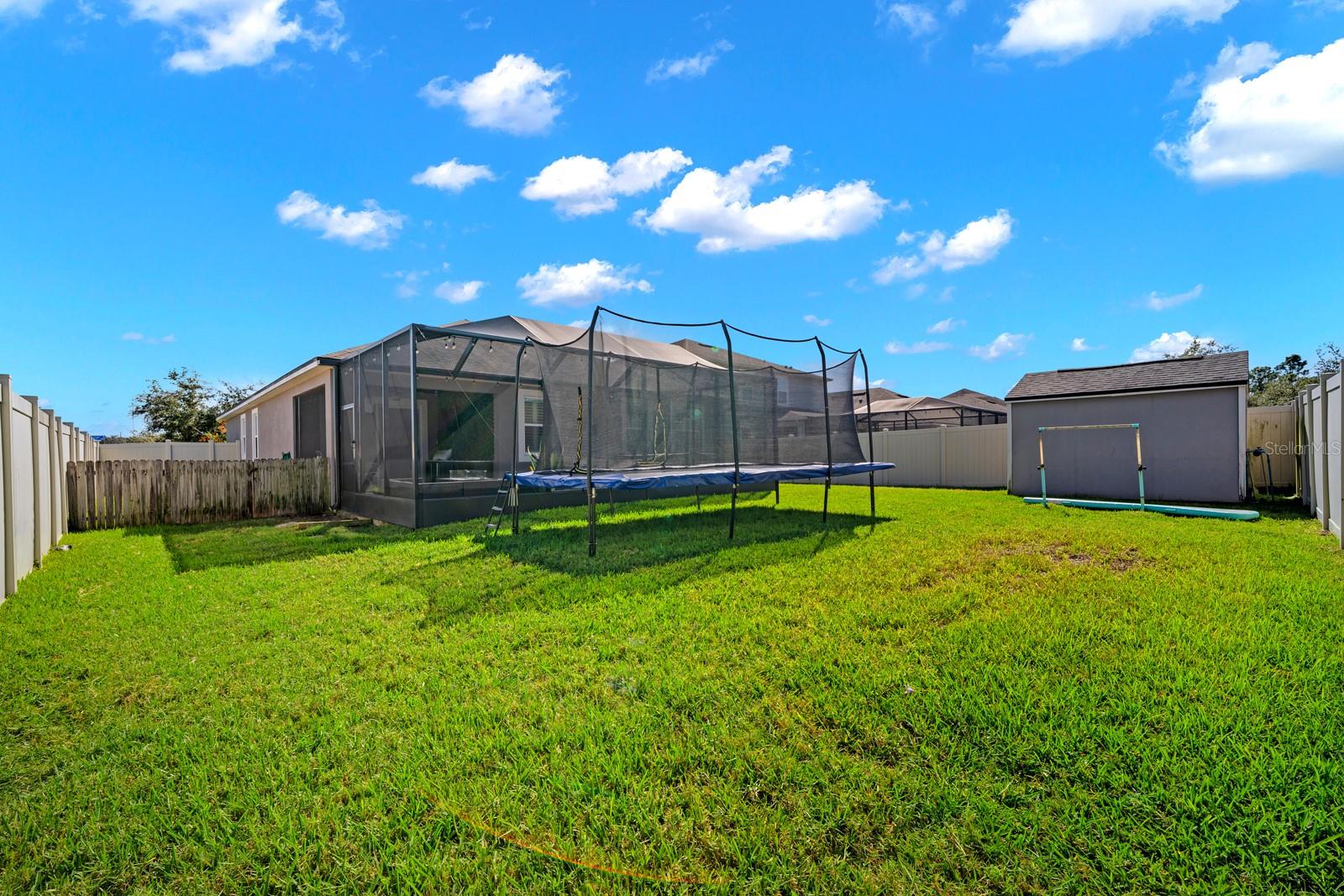 Backyard view of the screened lanai and storage shed