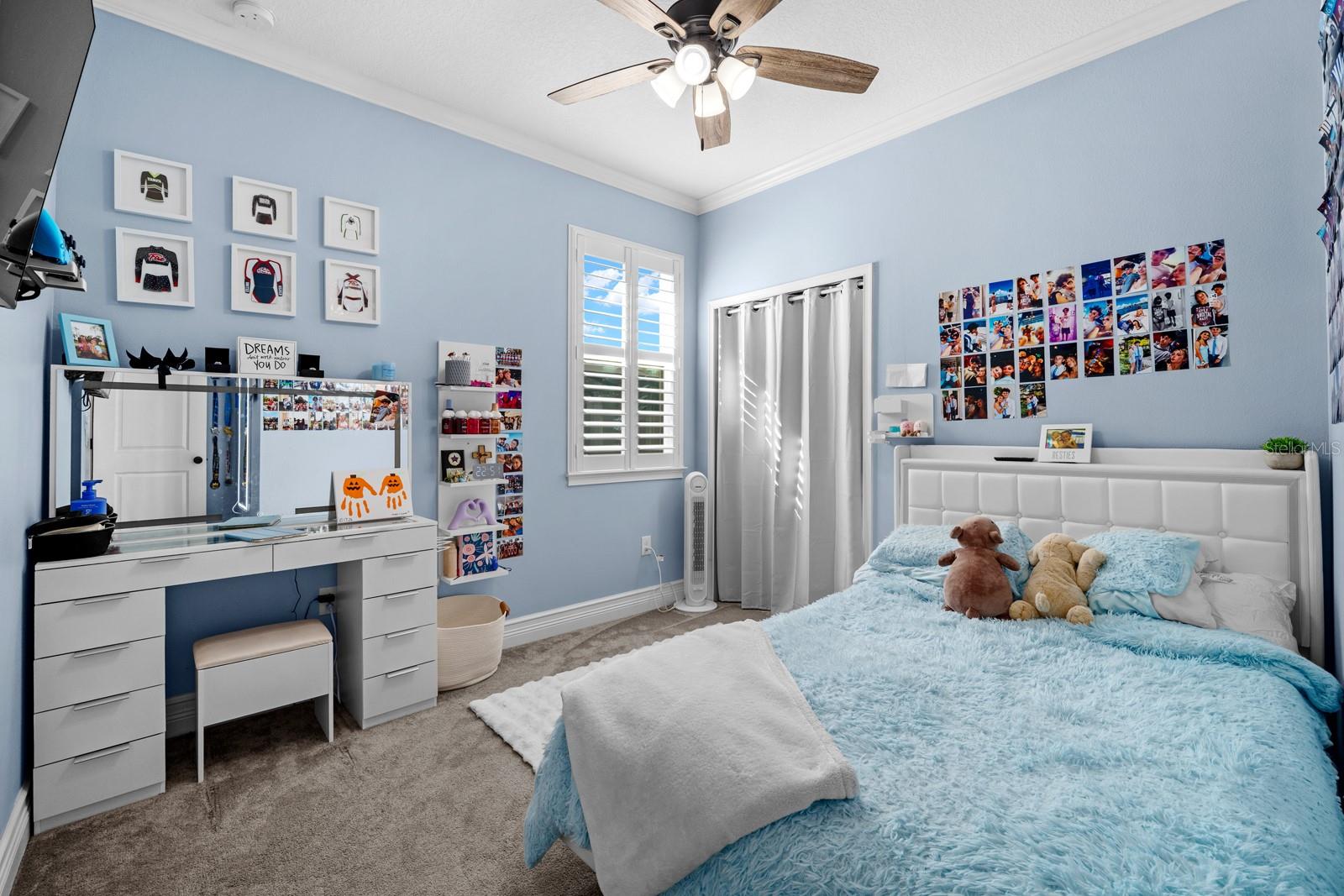 Bedroom with ceiling fan, plantation shutters and double-door closet