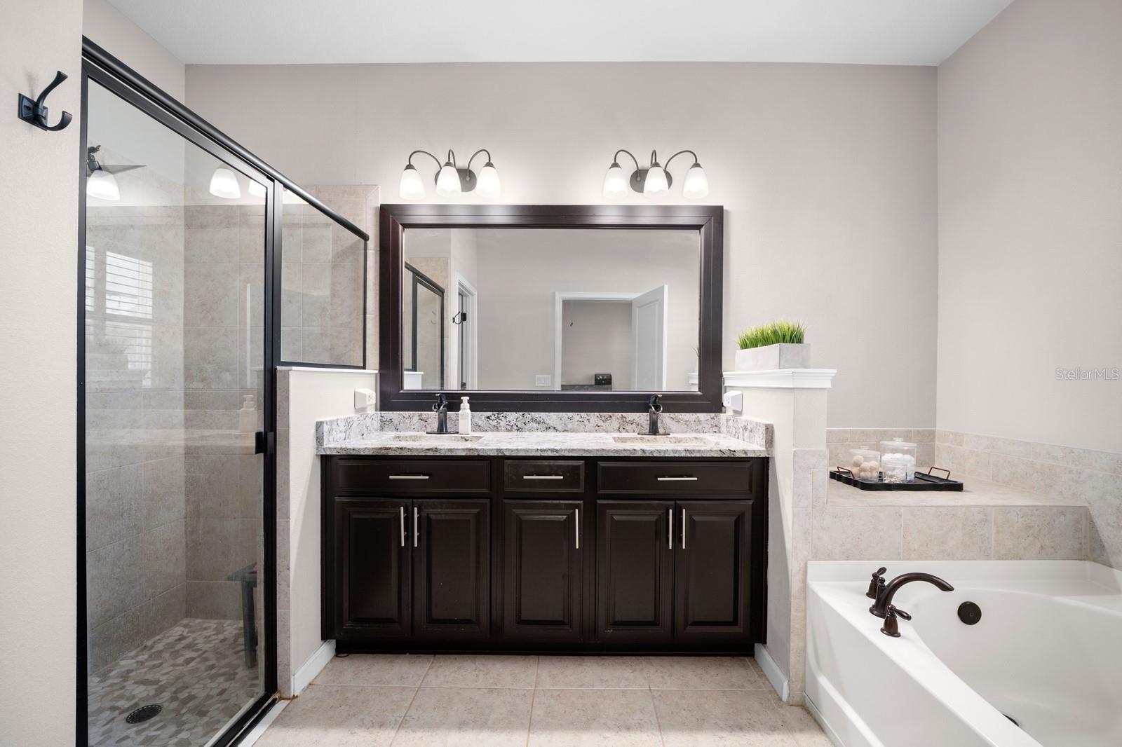 Primary bath with walk-in glass shower, dual vanity and garden tub