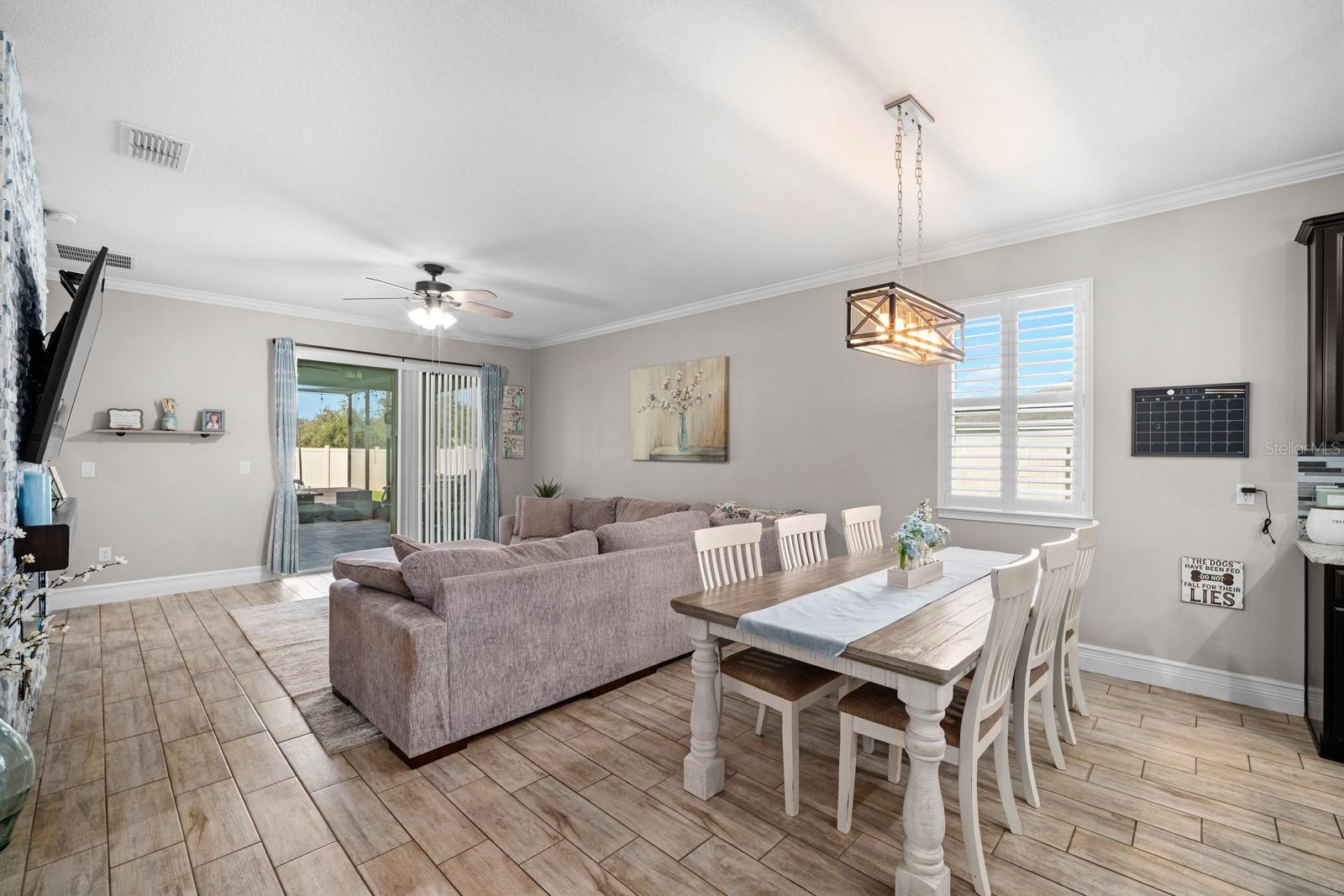 Dining area open to the family room, with wood-look tile throughout