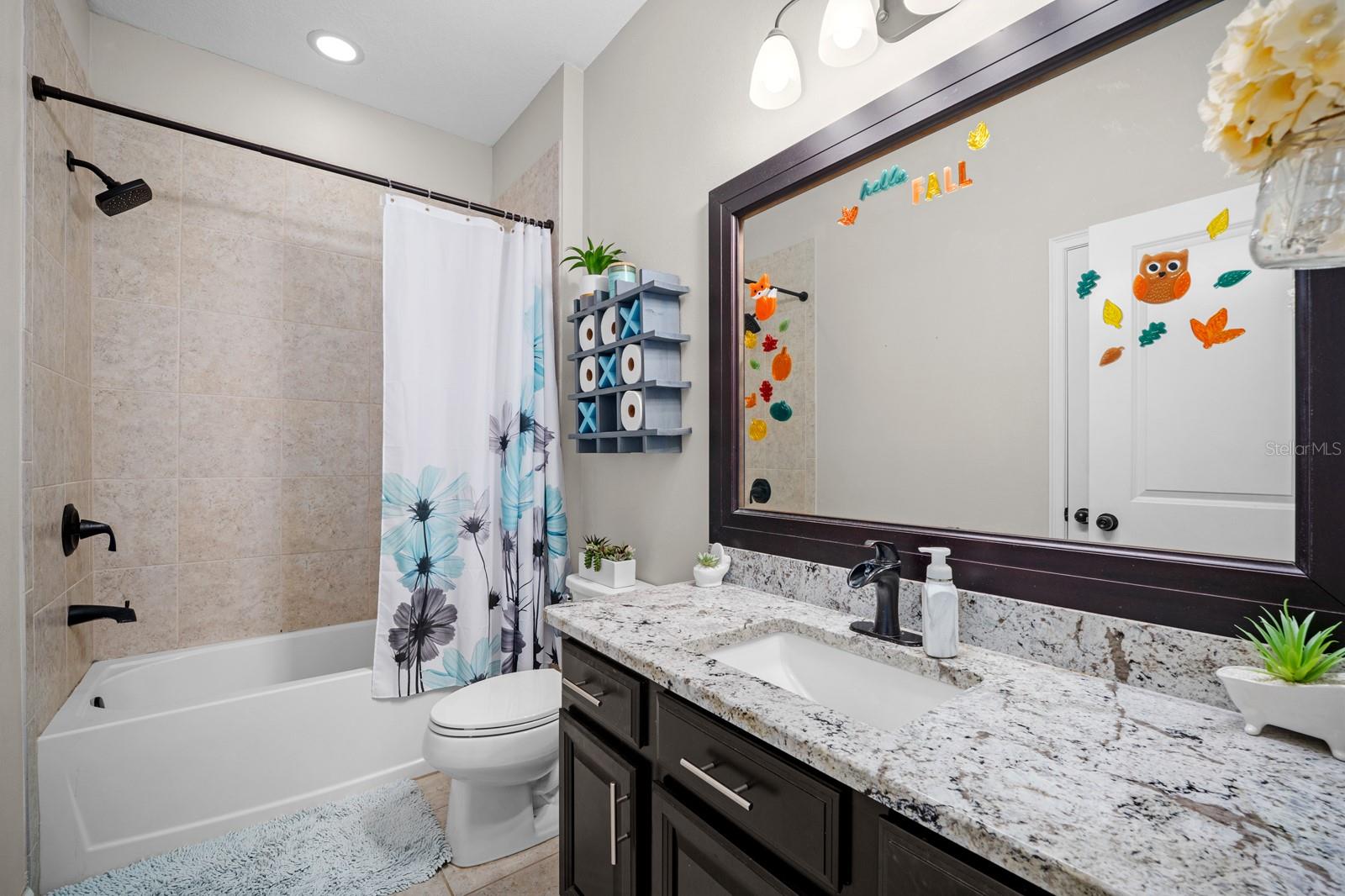 Hall bathroom with tub/shower combo and granite vanity