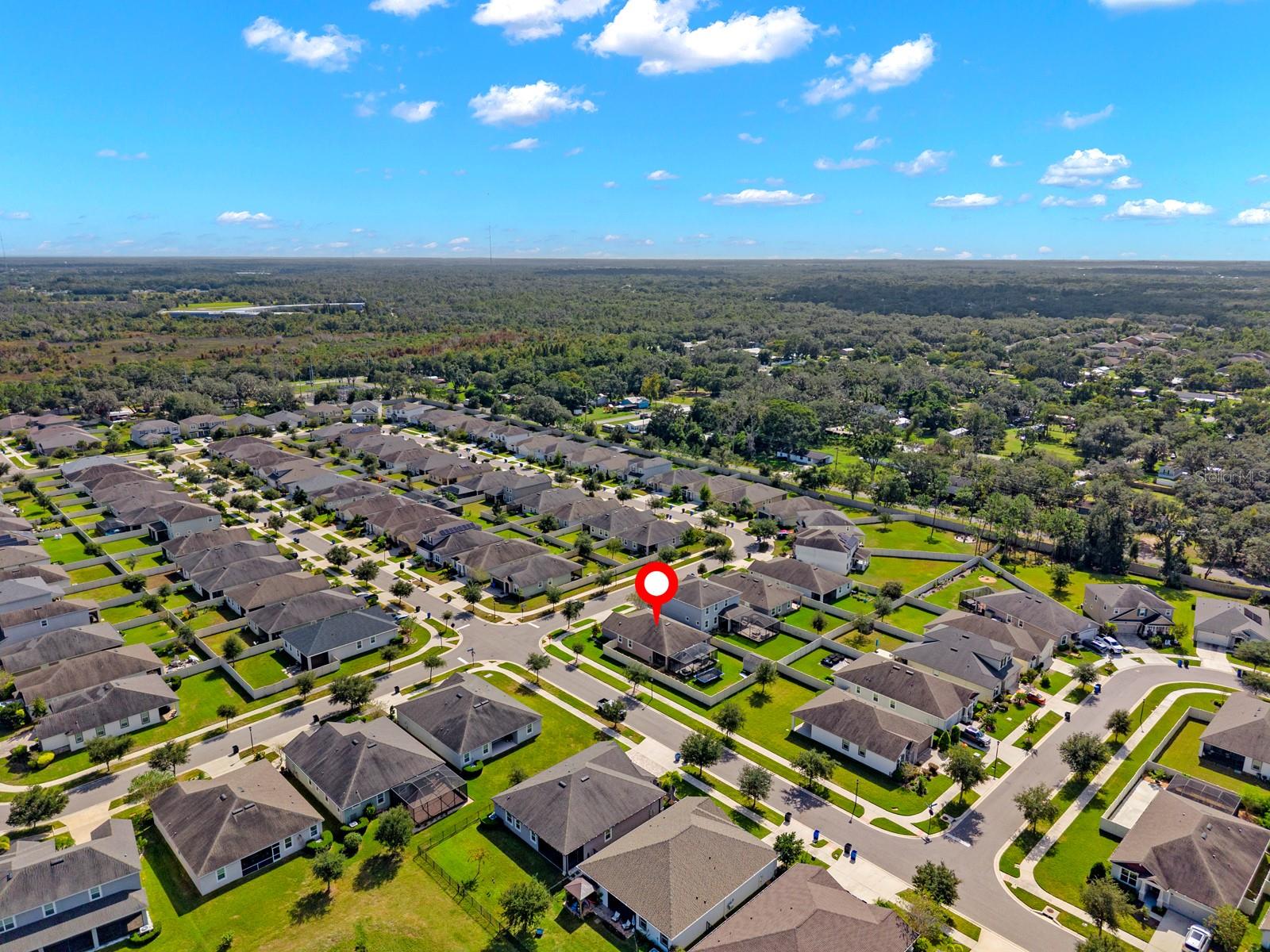 Wide aerial view with the home marked