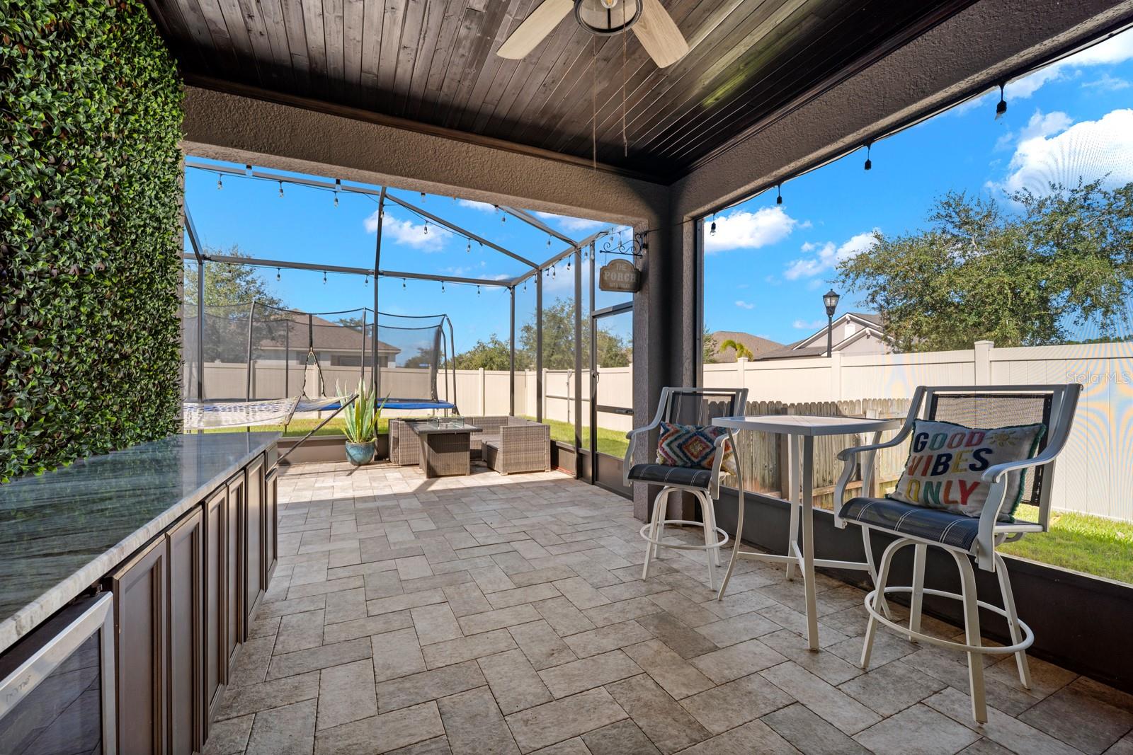 Screened lanai with bar seating and paver flooring