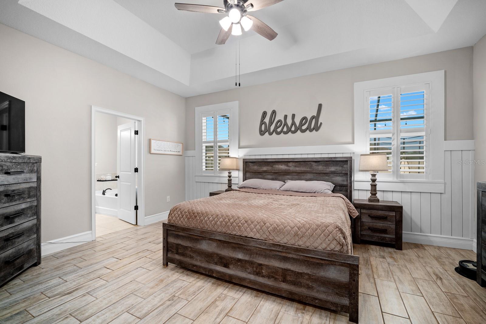 Primary bedroom with tray ceiling and private bath access