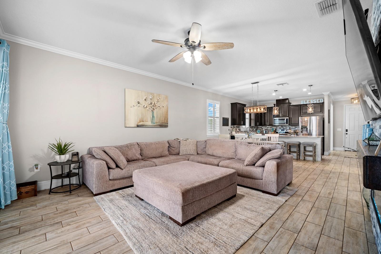 Family room with ceiling fan, open to the kitchen and dining area