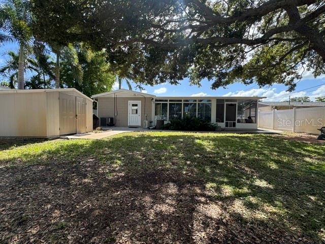 Rear view of backyard, residence, and storage shed