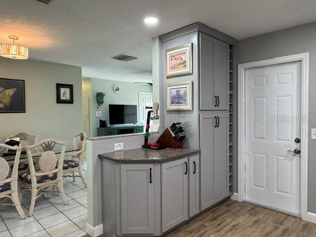 Kitchen view from sink showing garage entry, additional cabinents, and wine rack