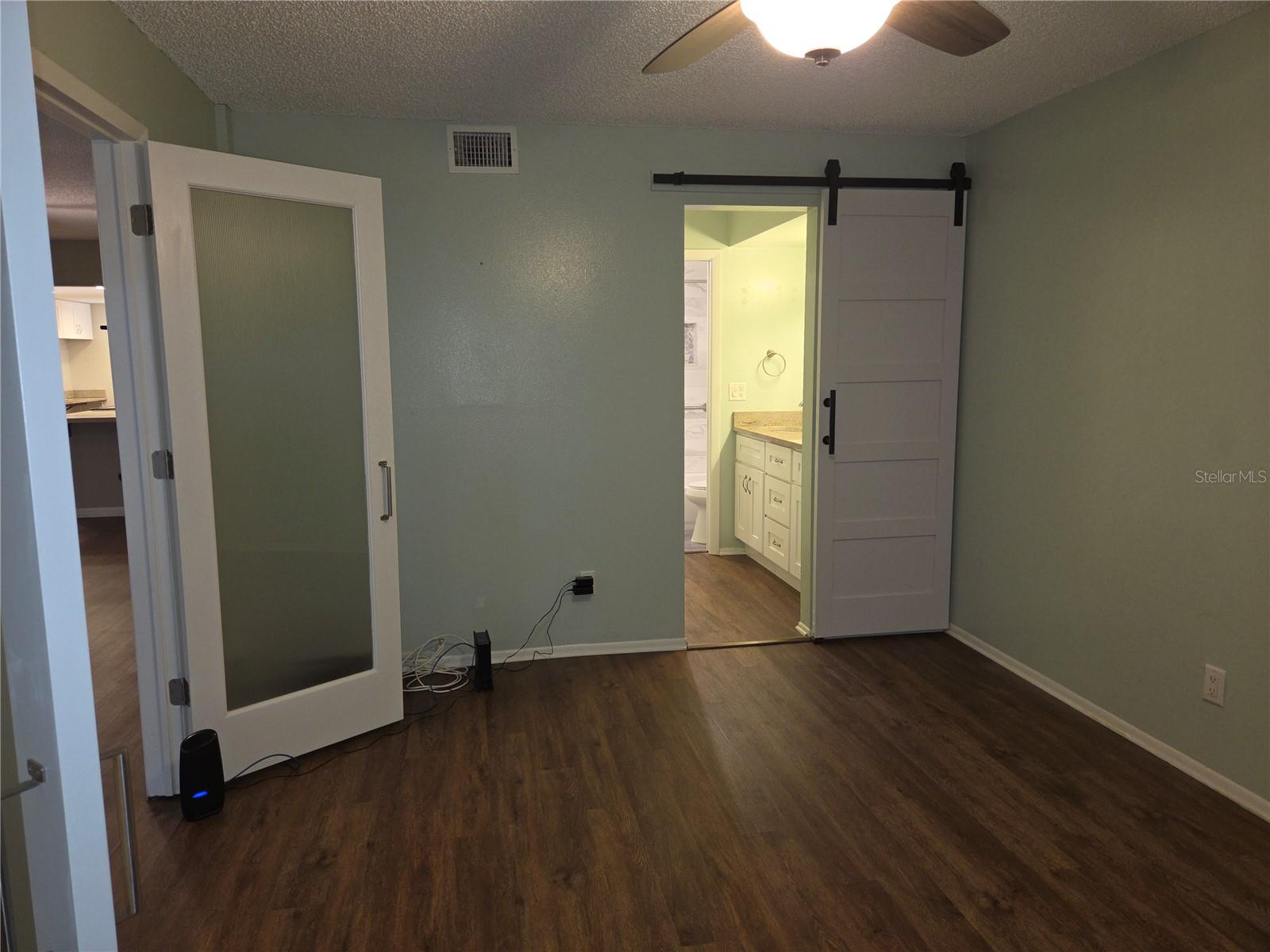 Entrance to ensuite bath from primary bedroom has a barn door.