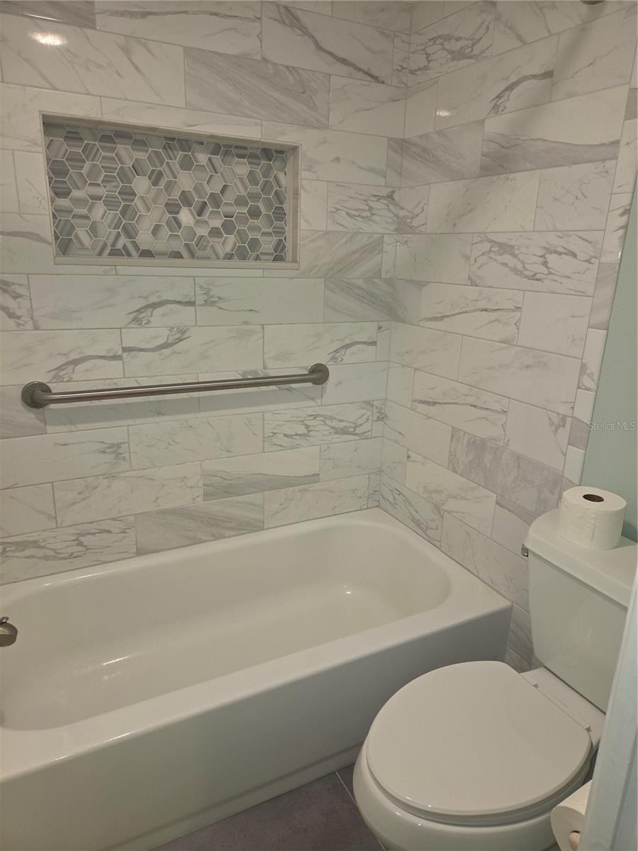 Primary bath tub with built-in shelf