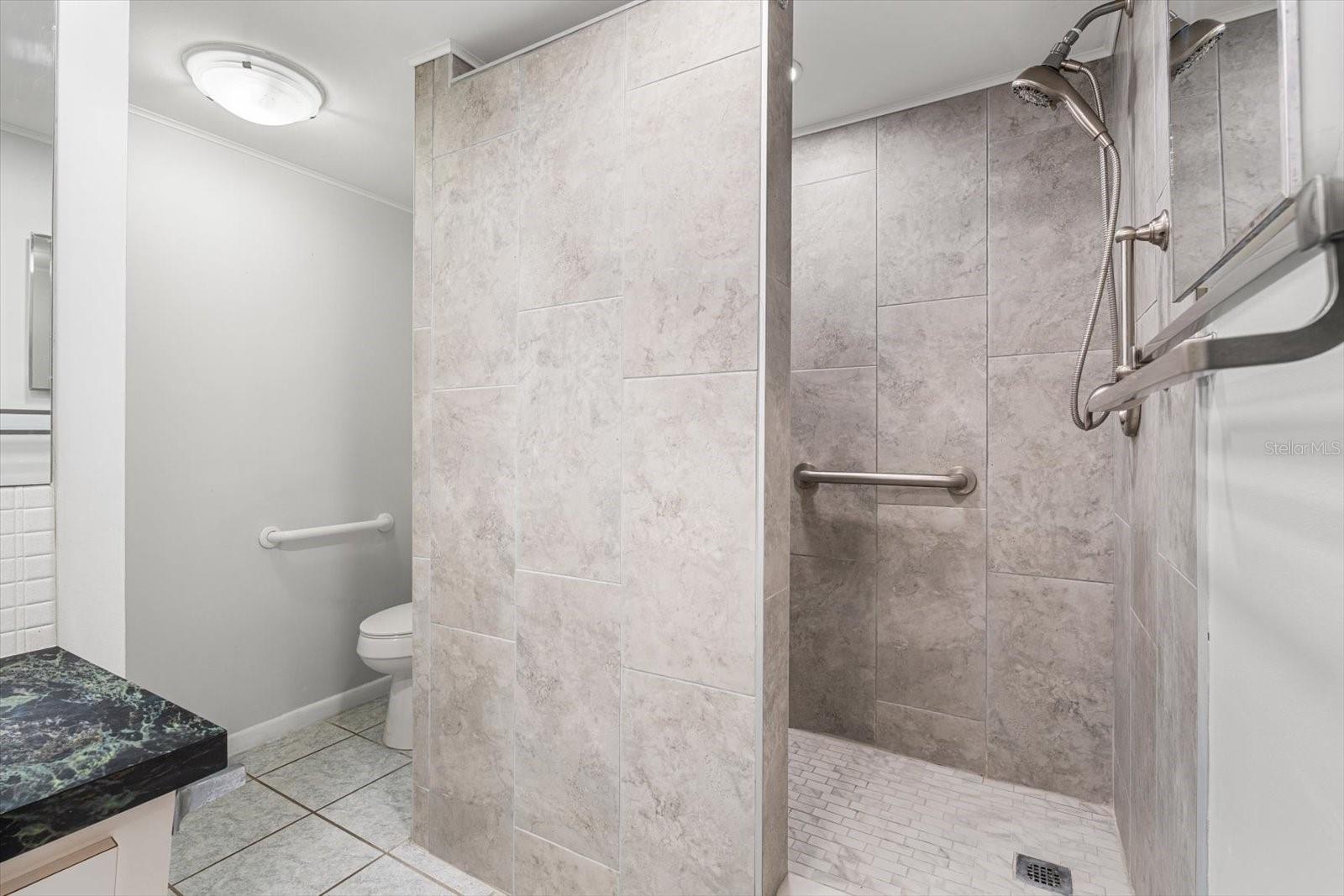 A large walk-in shower with a bench is featured in the primary bathroom.