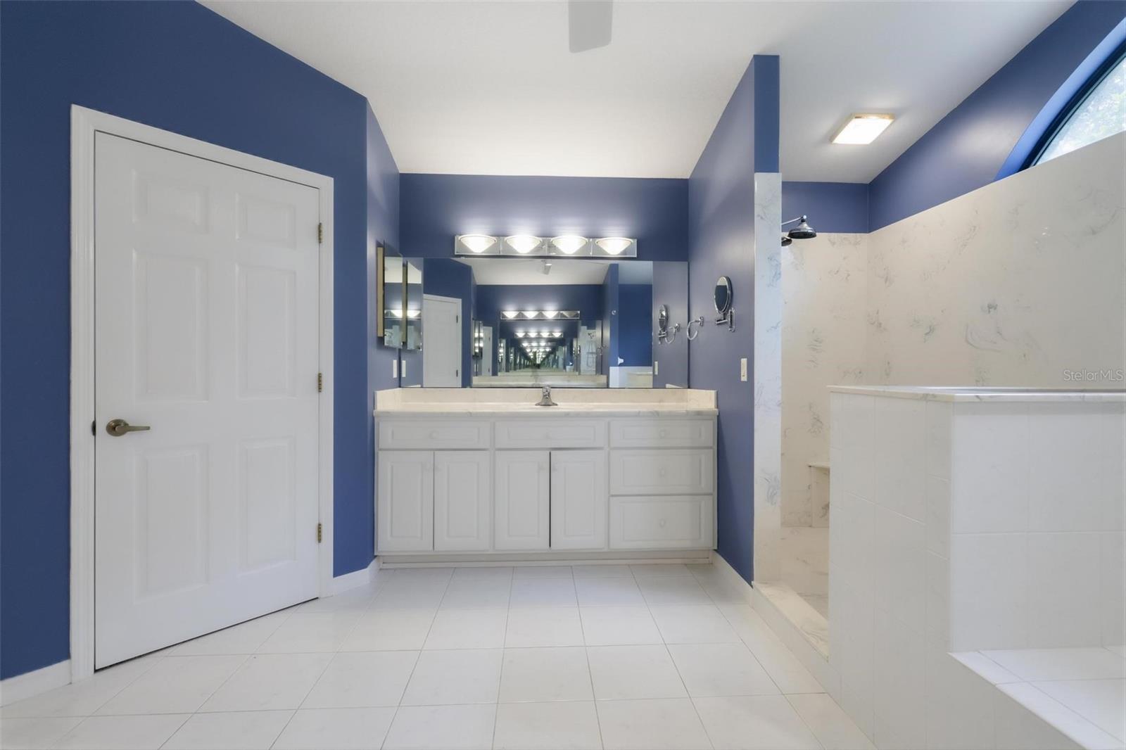 Primary bath, large shower, and large walk-in closet on left
