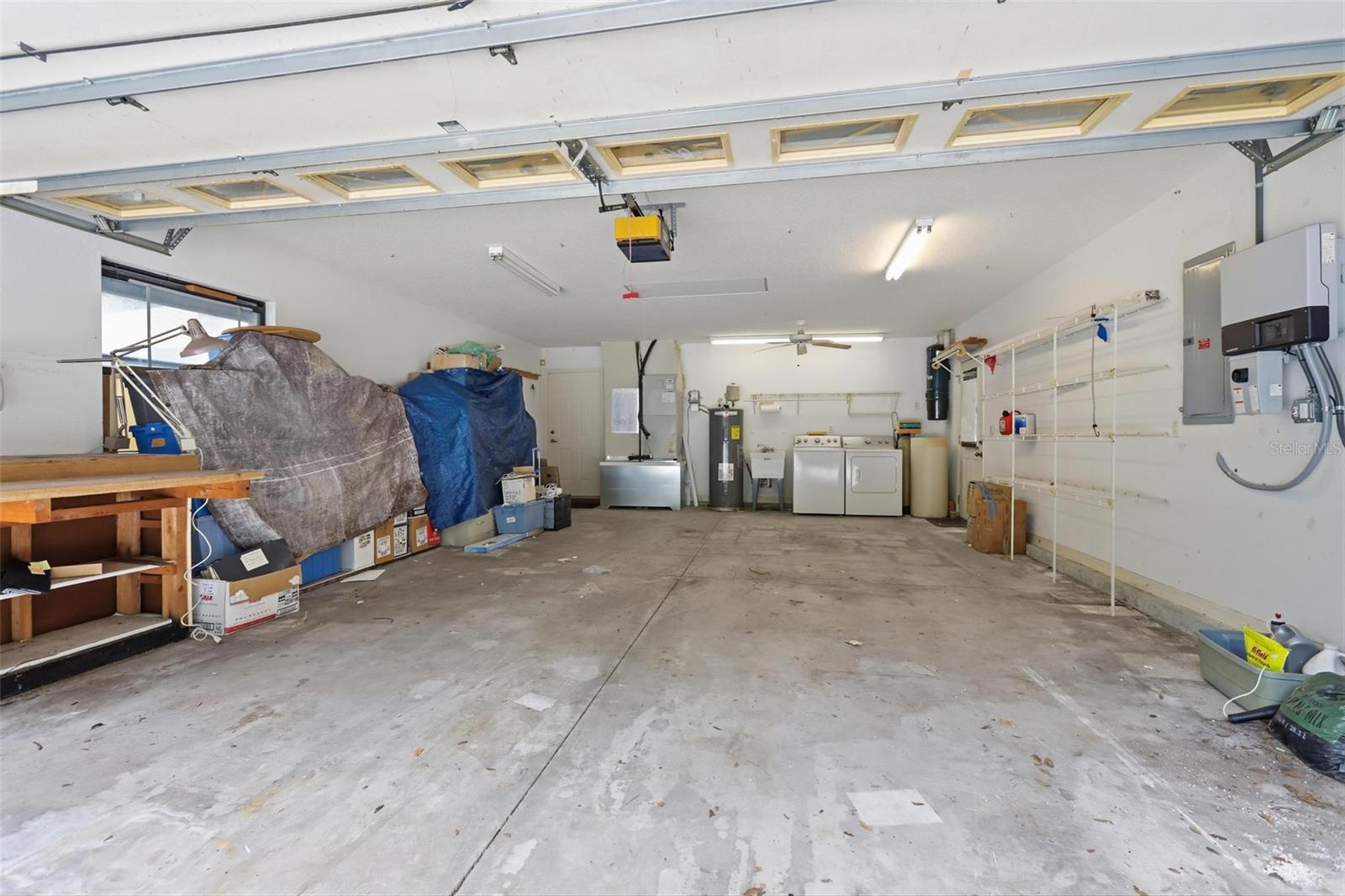 Extra deep (20') garage with workbench and A/C window unit on left.
