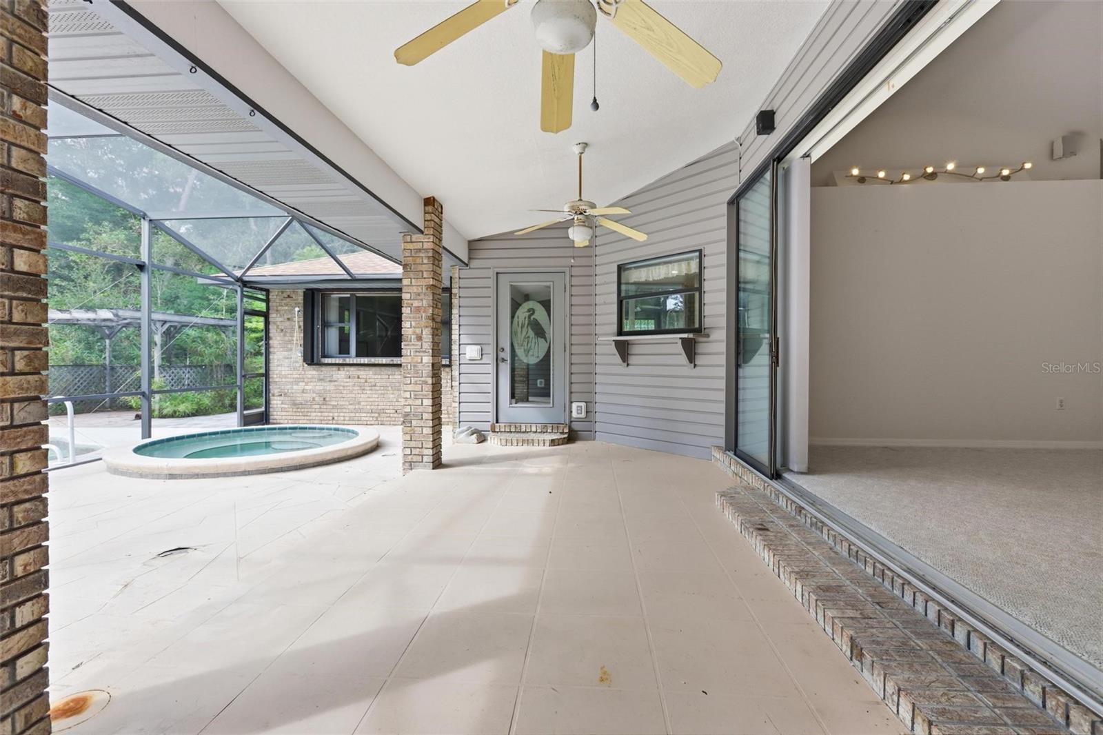 Back screened patio.  Living room on right, pass-through window into kitchen, entrance into kitchen, and spa.