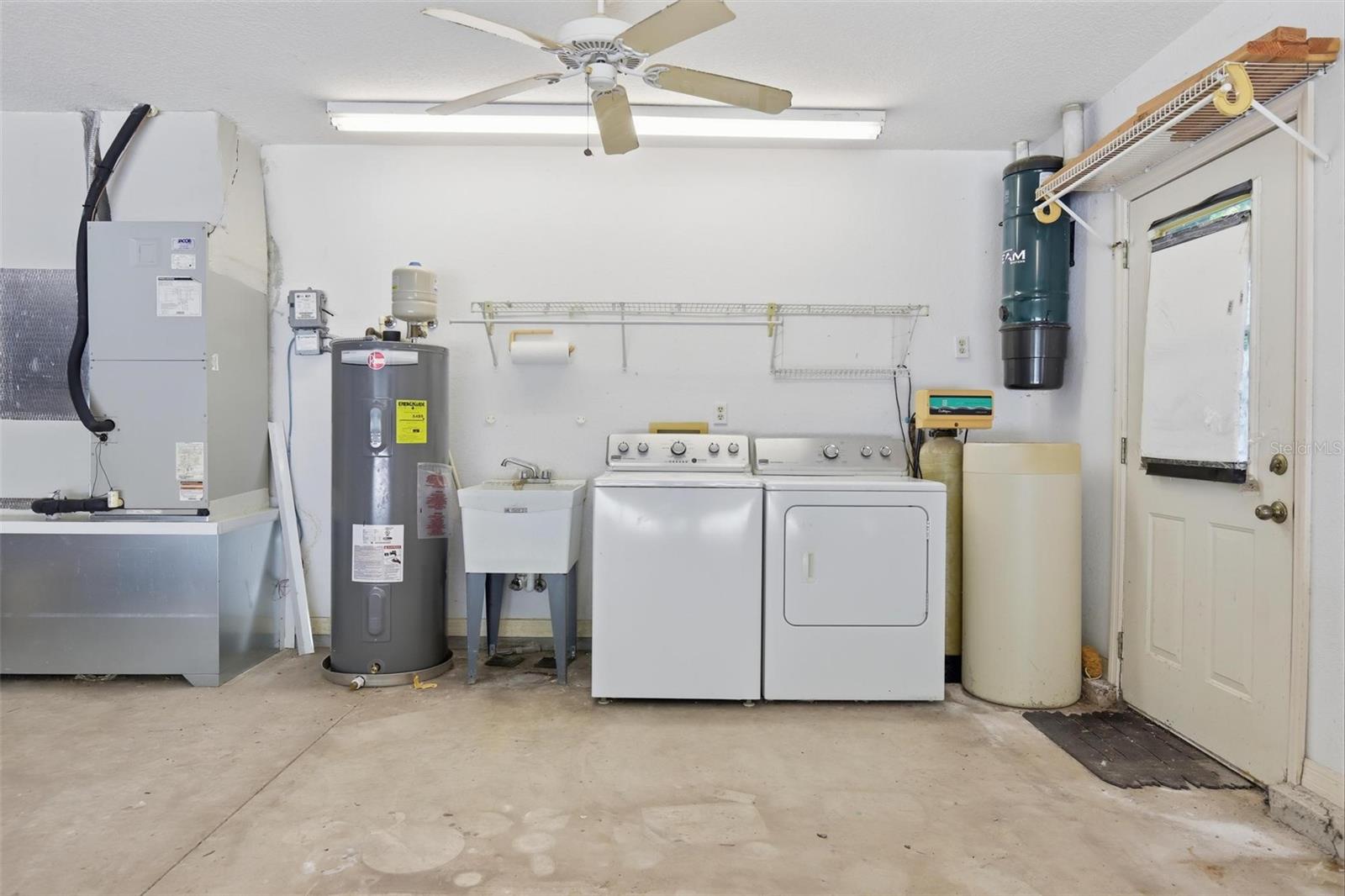 Air handler, water heater, utility sink, washer/dryer.  Entrance to side yard on right.