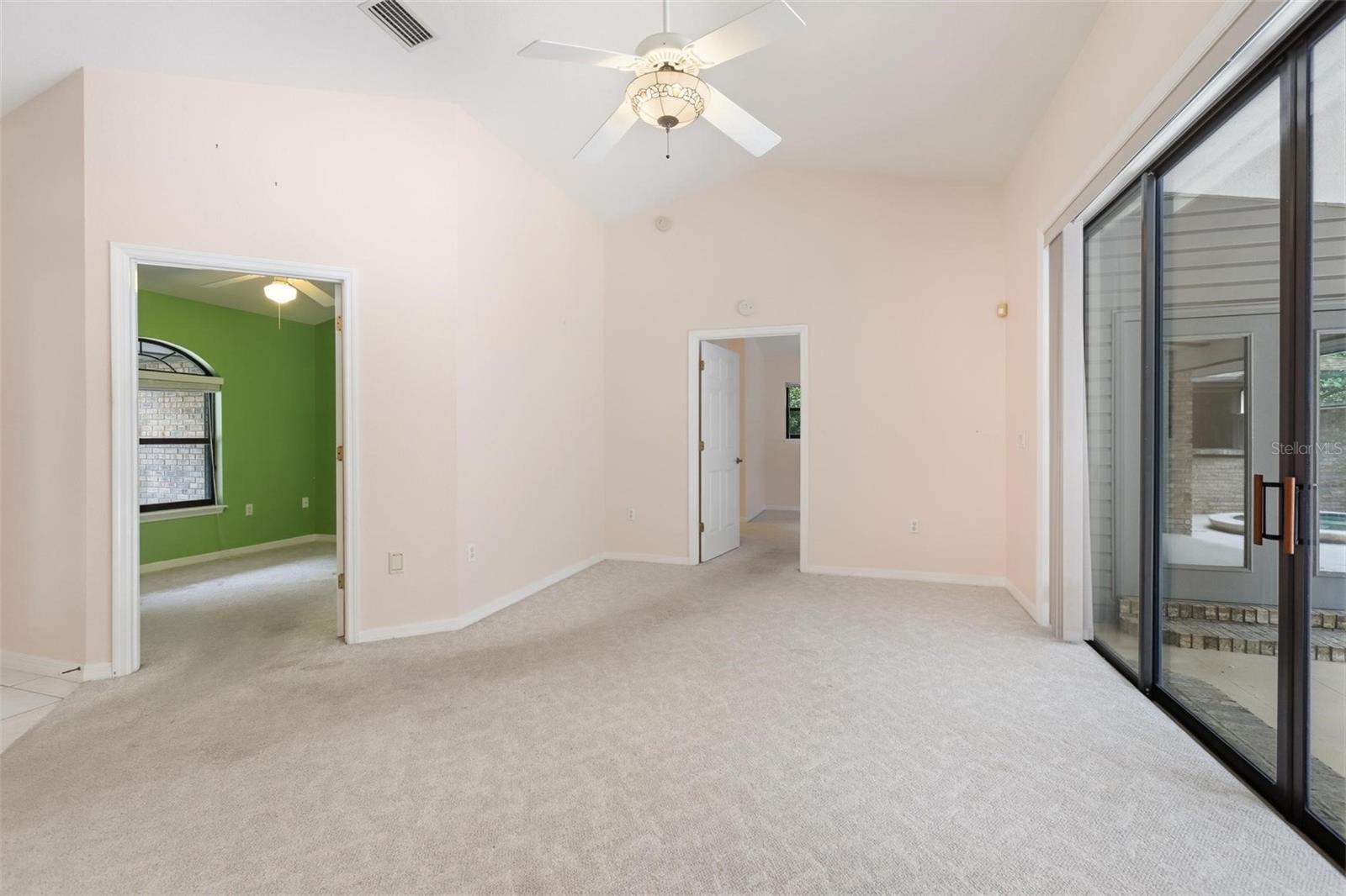 Living room looking into bedroom #3/office and primary bedroom.  Sliders on right completely "pancake" into wall.
