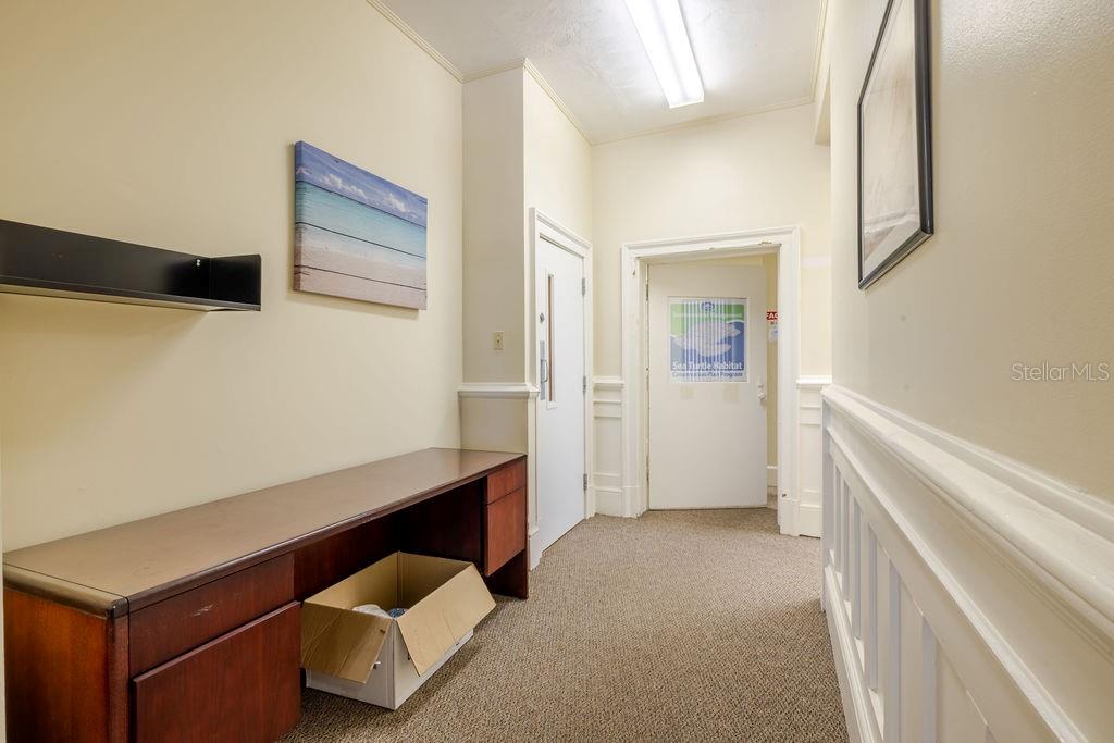First floor hallway leading to West side of property and interior basement door.