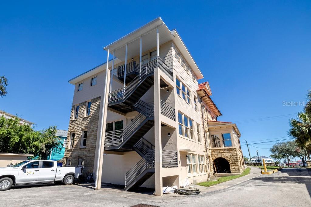 Newly constructed block and metal fire escape spanning the back of the main building.