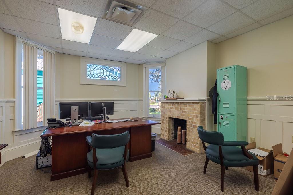 First floor office with stained glass accent window and historic masonry fireplace.