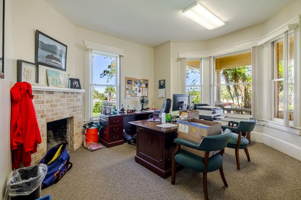 First floor office with oversized historic bay window facing the Halifax river. Historic masonry fireplace.