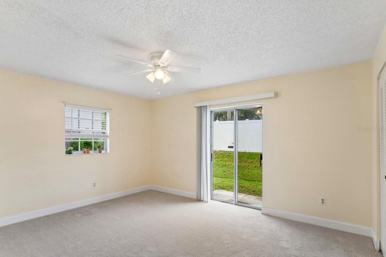 The bedroom has a slider, window, ceiling fan, access to the bathroom and walk in closet, and brand NEW carpeting.