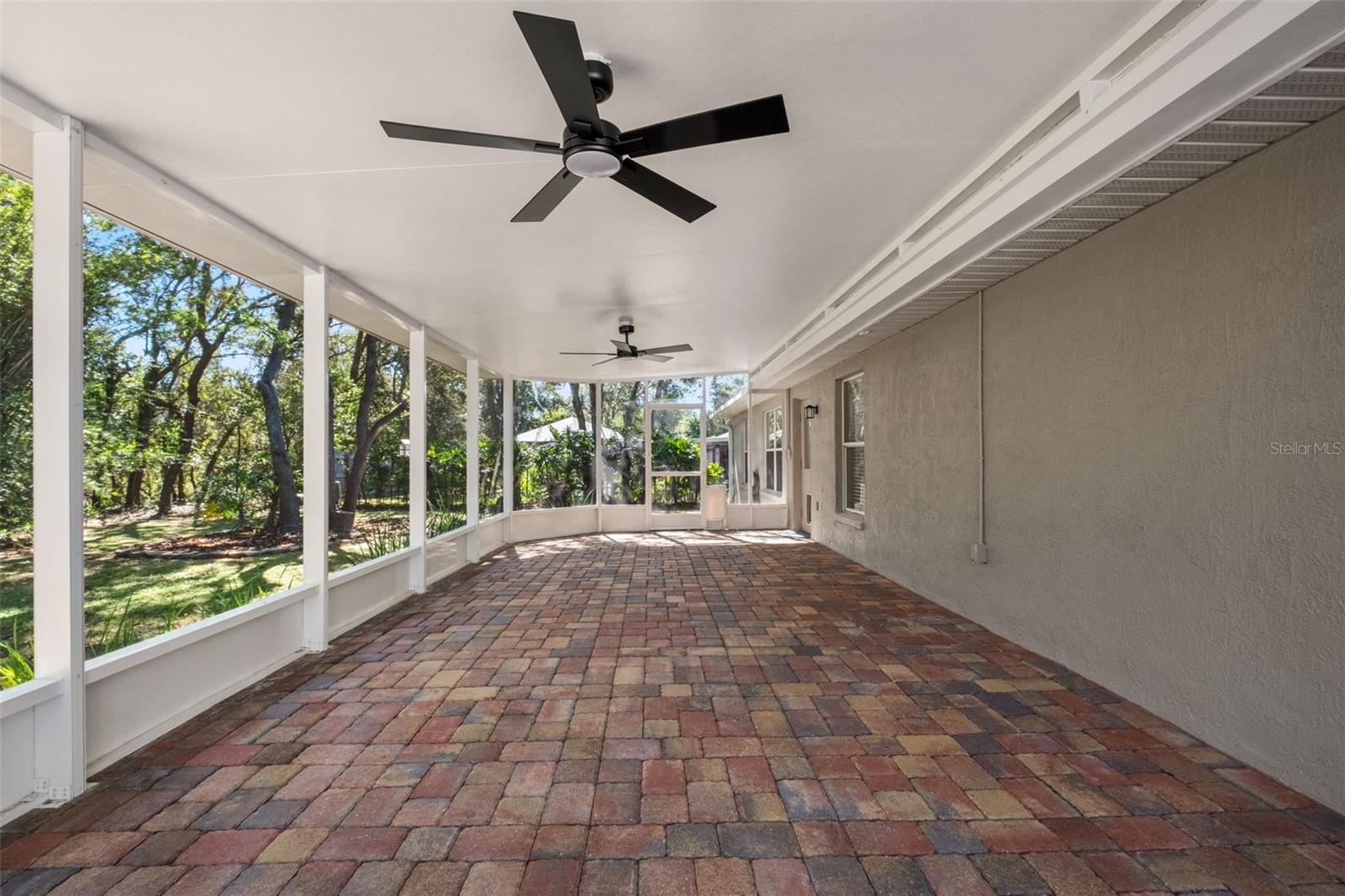 Expansive Screened Rear Porch with Pavers