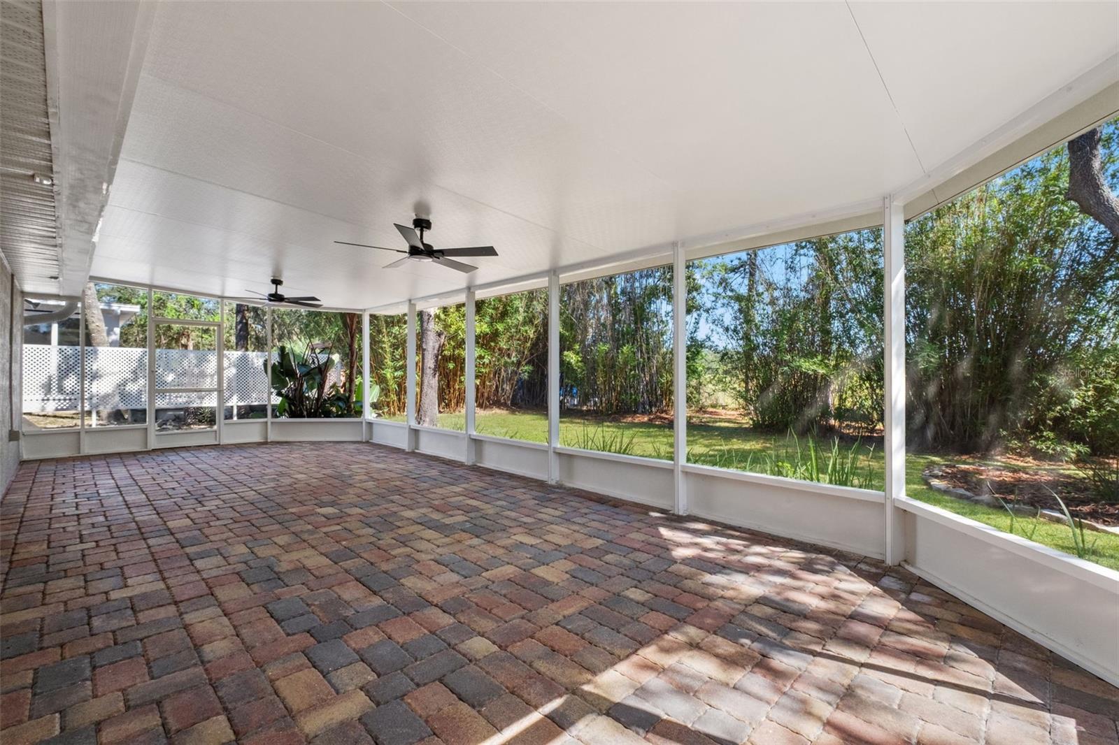 Expansive Screened Rear Porch with Pavers