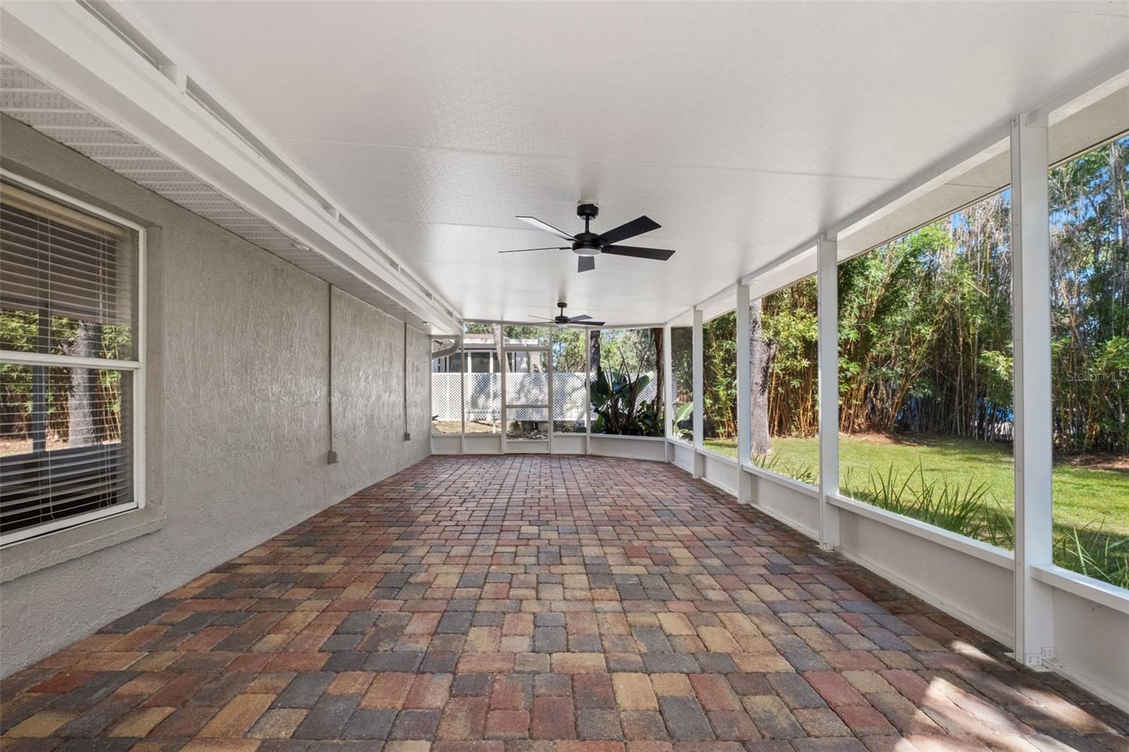 Expansive Screened Rear Porch with Pavers