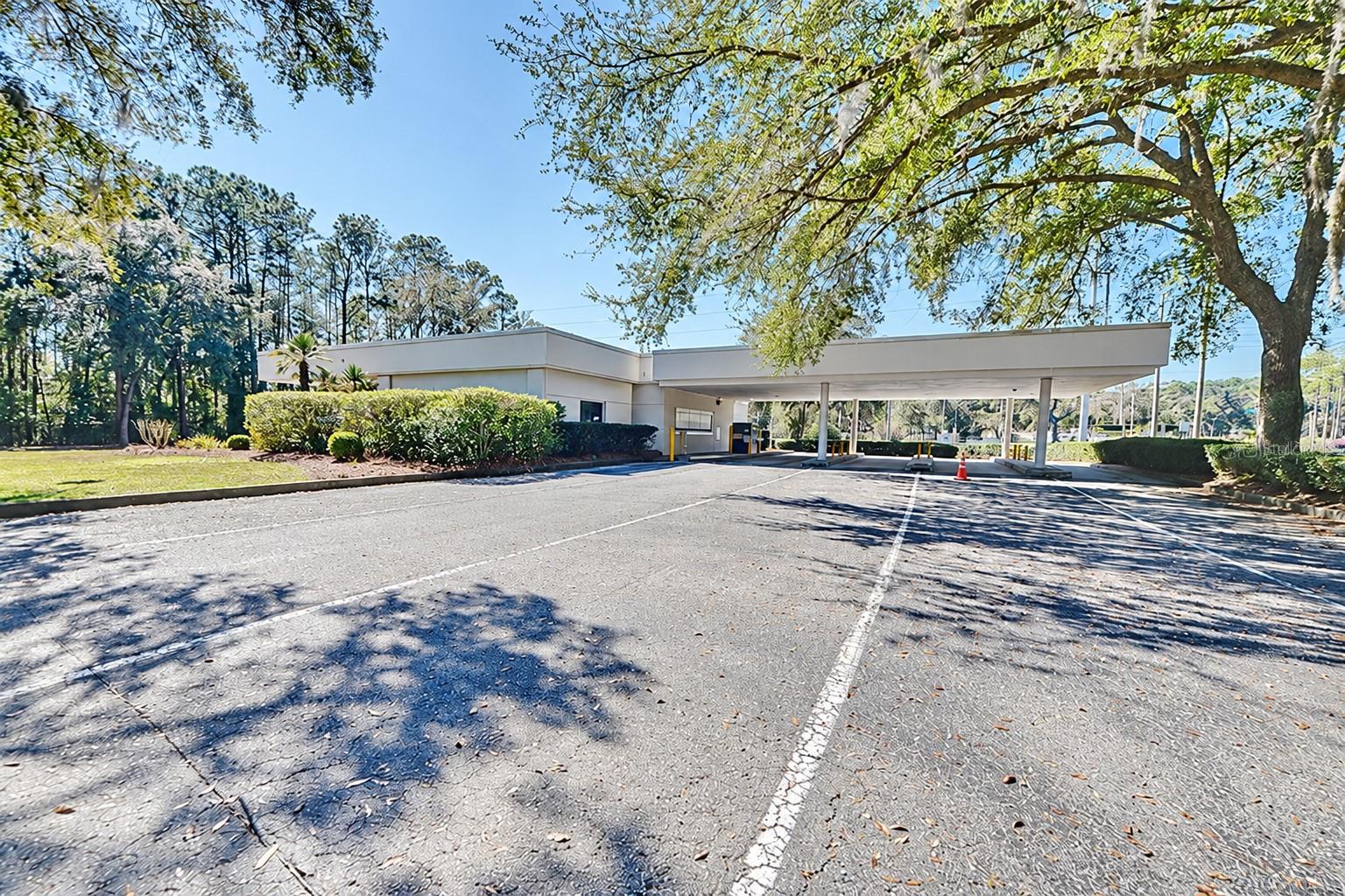 Rear view of the covered drive-through lanes. Digitally edited to remove former bank signage. Rear view of the covered drive-through lanes. Digitally edited to remove former bank signage.
